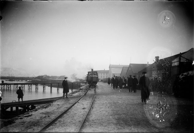 1913-1917 Eimreiðin á ferð í Reykjavíkurhöfn. Fólk á gangi. Brautarteinar.